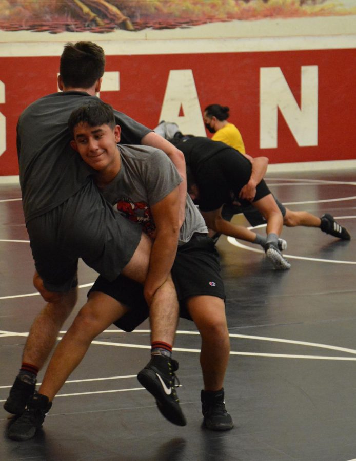 SQUARING+OFF+At+wrestling+practice+Nov.+15%2C+Cris+Silva%2C+freshman%2C+goes+over+basic+wrestling+moves+with+his+partner.+The+team%E2%80%99s+first+three+matches+were+cancelled+due+to+COVID-19%2C+so+their+first+match+is+Dec.+2+at+Andrean+at+6%3A30+p.m.+%E2%80%9CWe+were+just+reviewing+moves%2C%E2%80%9D+Silva+said%2C+%E2%80%9CSo+I+wasn%E2%80%99t+feeling+too+tired.%E2%80%9D