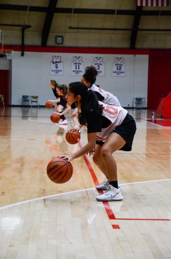 DRIBBLE IT, PASS IT: At their practice on Dec. 3, Mia Unzueta, freshman, runs dribbling drills with her teammates. Having a few bumps in the road due to Covid-19, “With a couple of girls being ill, we all work together as a team and fight through it,” she said.
