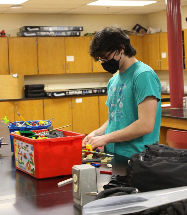 MODELING ASSISTANCE Making a model, Jacob Katz, junior, helps his teammates work on an event at practice. Jacob would create the model and hand it to another person for them to rebuild it. “I build with legos because they hold a lot of possibilities,” Jacob said. 