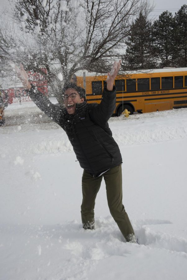 Gleefully frolicing, Anthony Young,  junior, plays in the snow outside MHS. “I feel overjoyed with the amount of snow!” he said.