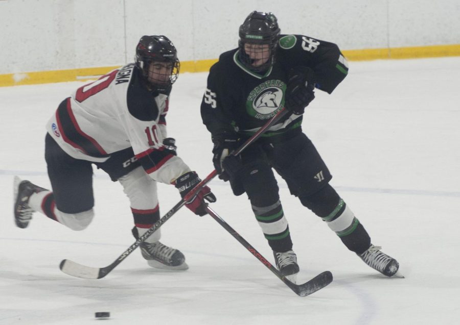 GLIDING ON ICE At the Kube Sports Complex freshman, Joey Campagna, freshman, races for the puck in a scrimage game against the Spartans.  