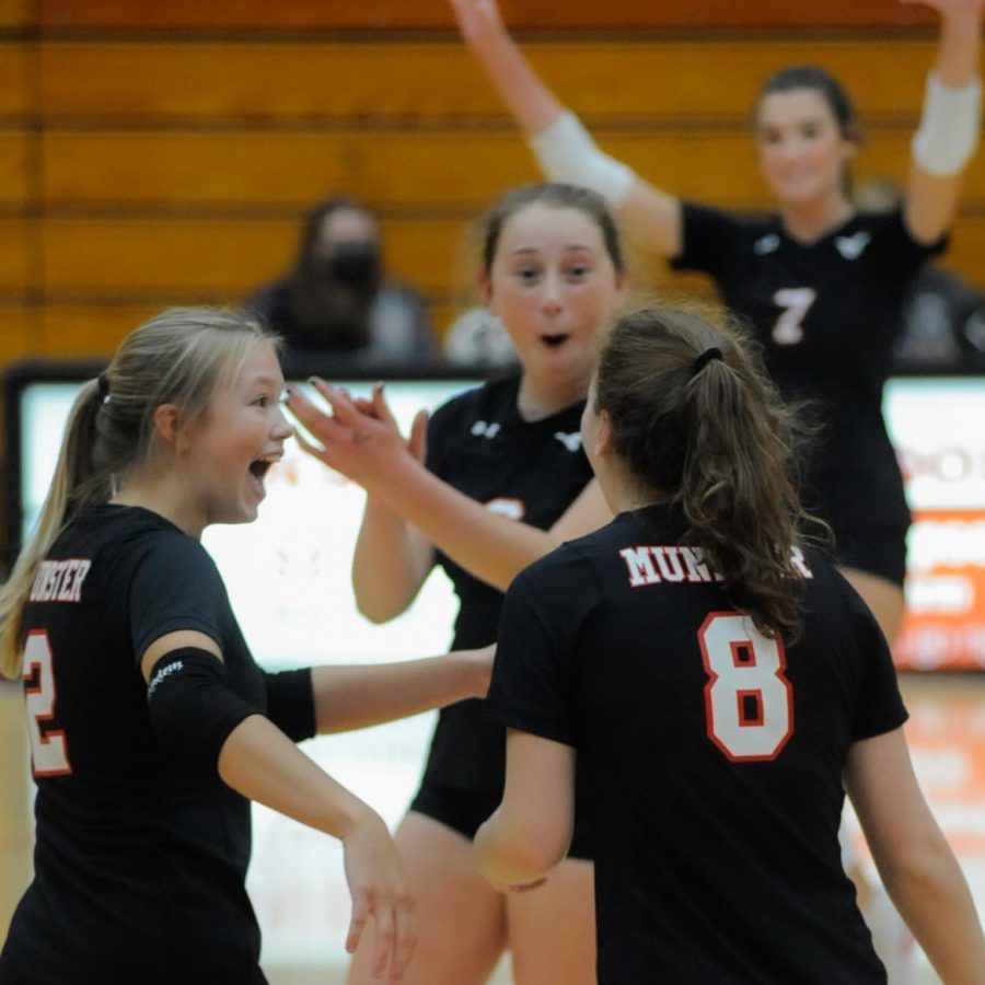 WICKED WIN Celebrating after scoring a point, seniors Emma Miles, Marina Gronkiewicz and Grace Clark, win their game against Hobart on Sept. 9. “Despite even the score, I felt confident in us and knew we were going to pull through,” Marina Gronkiewicz, senior, said. 