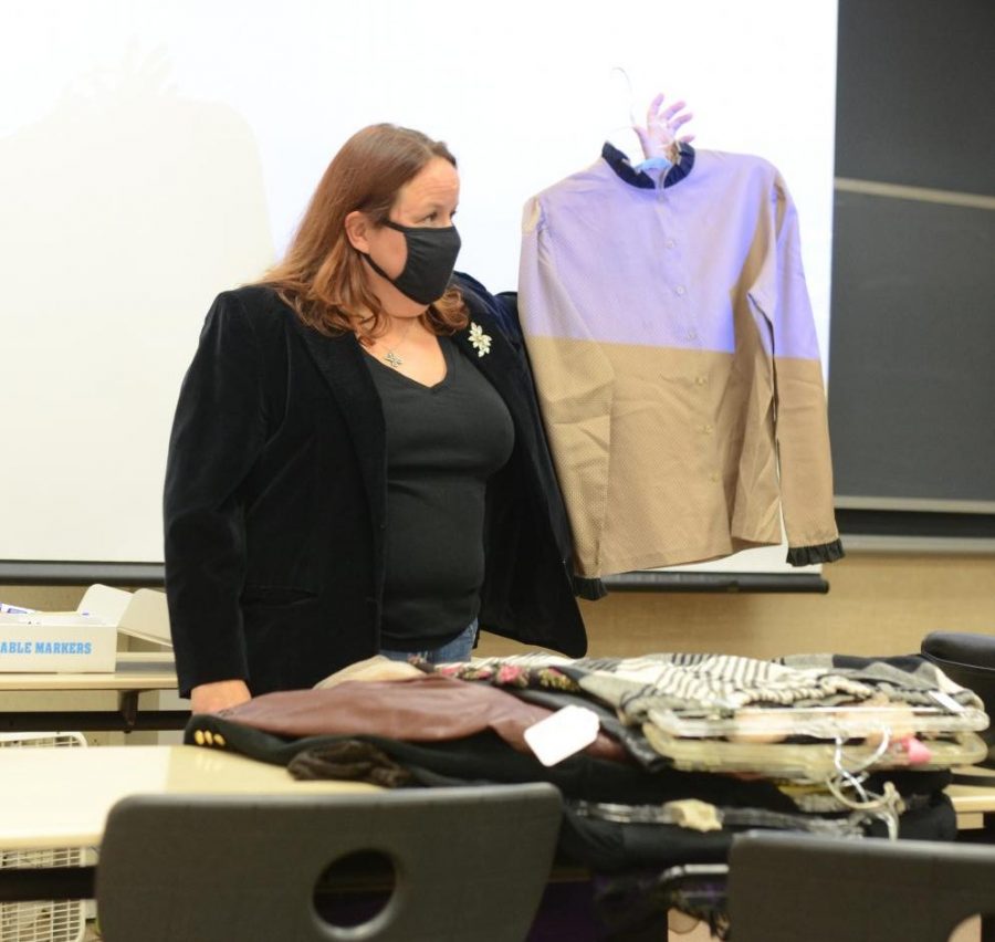 FASHION FORWARD Holding up a vintage piece during a Womens Empowerment club meeting, guest speaker ______ gives gives a presentation about womens fashion. 
