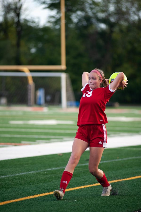 SCORING SCREAMERS 
Tossing the ball into play, Piper Swope, junior, sets her teammates up for a goal. “The soccer season was probably the most family and team I’ve felt in a while,” Piper Swope, junior, said.