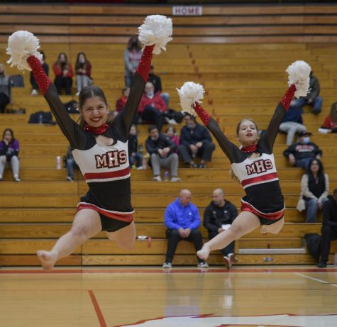 JUMPING IN SYNC Peyton Collier, senior, and Kayla Bell, sophomore, do a front leap during halftime performance. Since this is my last year dancing, I want to make it count, Collier said. 