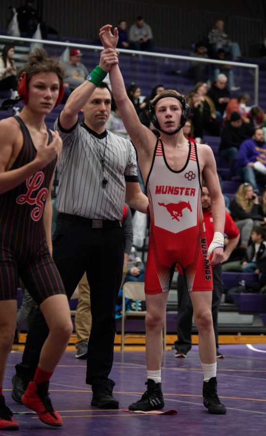 MAKING A STATEMENT After the final regional wrestling match at Hobart high school, the referee raises Christopher Bohn’s, sophomore, arm after he wins first place. 