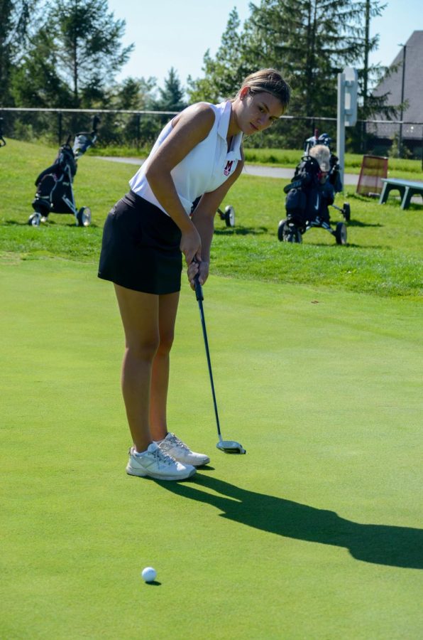 HITTING+THE+CLUB+Standing+on+the+green%2C+Alexis+Schmidt%2C+junior%2C+lines+up+her+shot.