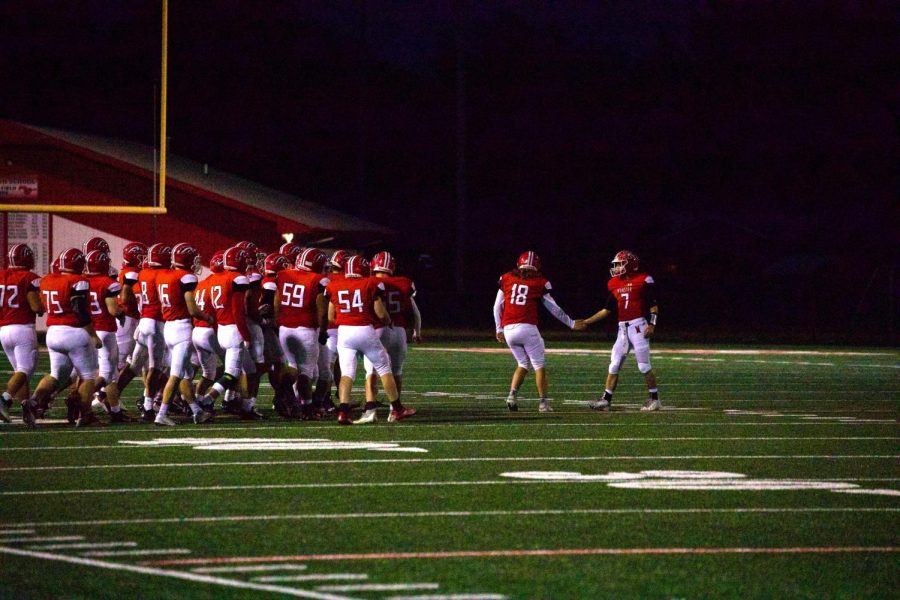 TEAMWORK MAKES THE DREAM WORK As the team walks onto the field, senior AJ Prieboy and junior Matt Opat shake hands before a play. On Sept. 23, Munster lost to Highland 7-12.  
