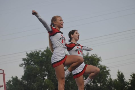 STRIKE A POSE Performing an extension lib, Lauren Sims, junior, and Scarlett Mrvan, sophomore, cheer into the crowd during the Aug. 26 football game. “My favorite part of cheer are the team bonding days, having fun at games and seeing our friends in the crowd,” Mrvan said. 