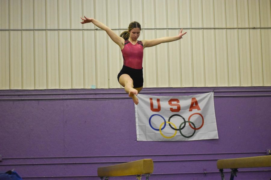TAKING THE LEAP Trying to keep her balance, Jenna Skipper, senior, preforms a split jump on the balance beam. ”I try to focus on one thing so I don’t fall,” Skipper said.