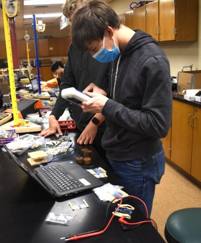 HIGH VOLTAGE In the Science Olympiad lab, students Stephen Glombicki, sophomore, and Daniel Eriks, senior, test the voltage of a wire. (photo by ethan pischner)