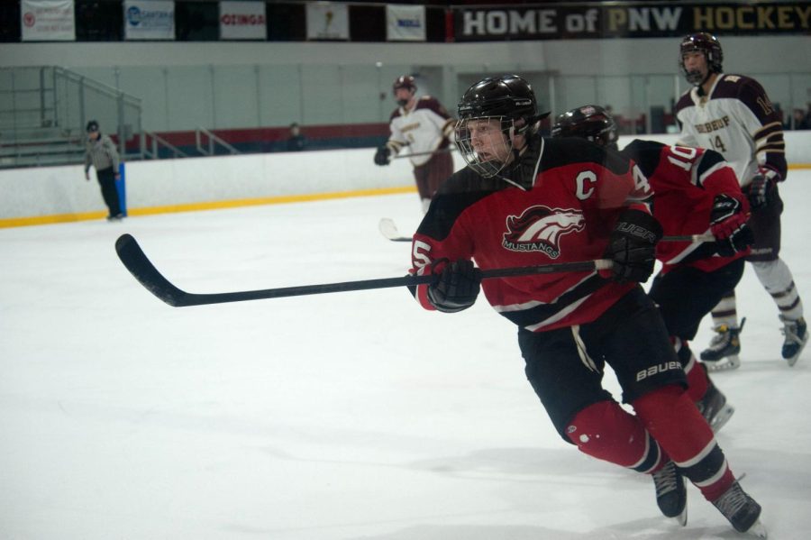 ON THE FLY During their game against Brebeuf Jesuit Prep, Brenden Budeselich, senior,  chases after the puck. Ending with a 4-4 tie, the team nears closer to their State Championship on Feb. 24