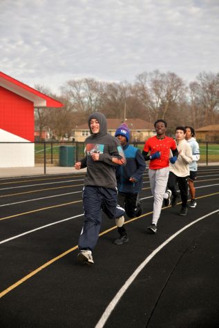 FOLLOW THE LEADER Turning the corner, from left to right, seniors Corey Dennis and Dayo Adeoye, sophomores Kwaku Awuah and Ryan Bouktache and Jacob Mazumdar, senior, run their warm up laps in preparation for their upcoming meet. 