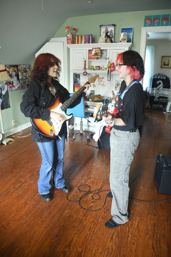 STRUMMING AWAY Playing the guitar and bass, Olivia Olivares and Vane Rodriguez, sophomores, practice a song together. With Battle of the Bands approaching, they are getting in as much practice as possible.