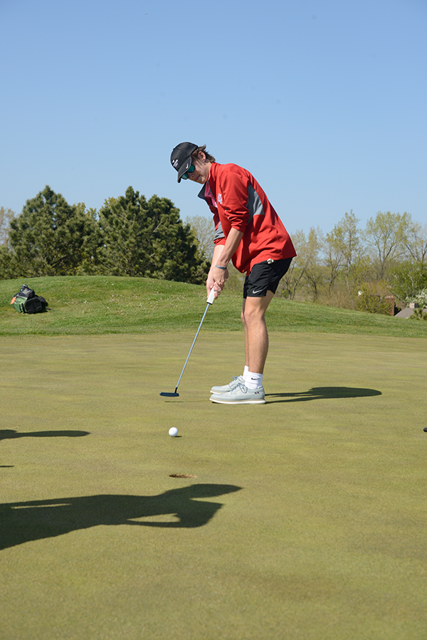 PUTTING AROUND As he practices on the Centennial course, Torin Mulcahy, junior, takes his turn on the putting green. 