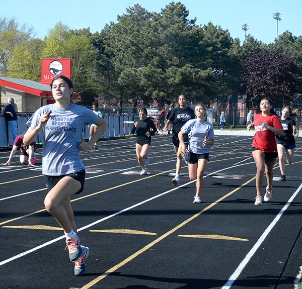 RACING FOR RESULTS Racing across the track, Cate Stephan, junior, and Liliana Rivera, sophomore, practice for track. In the wake of an undefeated regular season, MHS’ girls track team has been working hard to keep their streak.