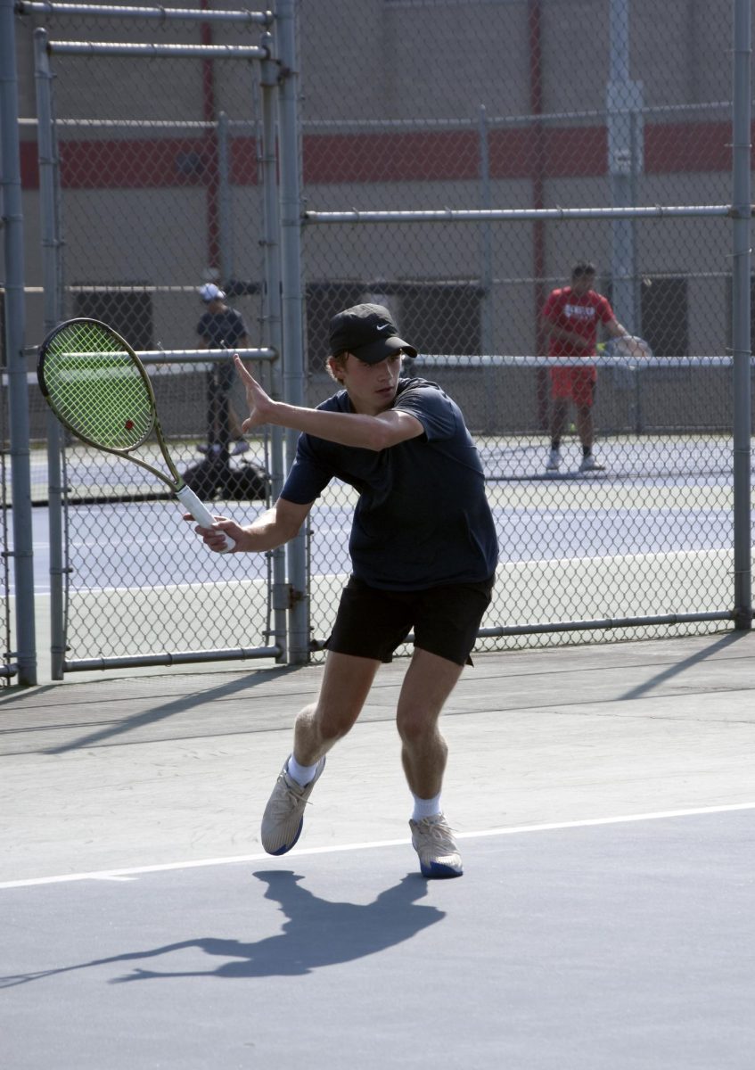 TENNIS FINESSE At practice, Michael Fesko, senior, prepares to rebound the ball back to Coach Spohr. Fesko states that, “Everytime I go to play a match my personal goal is to find a way to win, help out the team, and to win as many matches as I can.” “Our team slogan is ‘Now or Never’, as we have a lot of seniors, so we are aiming to accomplish a lot for our last season together.” Fesko finishes by saying, “I want to give everything I have to this last year so I can look back with no regrets when I am done.”  (photo by marianna young)