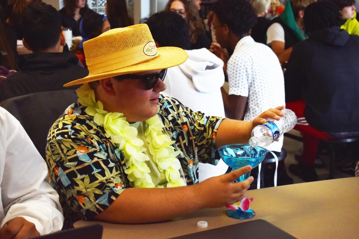 CHEESEBURGER IN PARADISE Pouring more water into his margarita glass during lunch, Michael Burzynski, senior, dressed as Jimmy Buffet—complete with Jimmy Buffet Crocs—for senior random costume day on Tuesday. 
