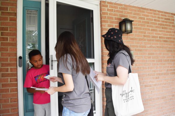 DOOR TO DOOR Sophomores Kristie Tong and Grace Wang walk through the Frank H. neighborhood selling tickets for the chicken dinner that the Speech and Debate team is hosting. 