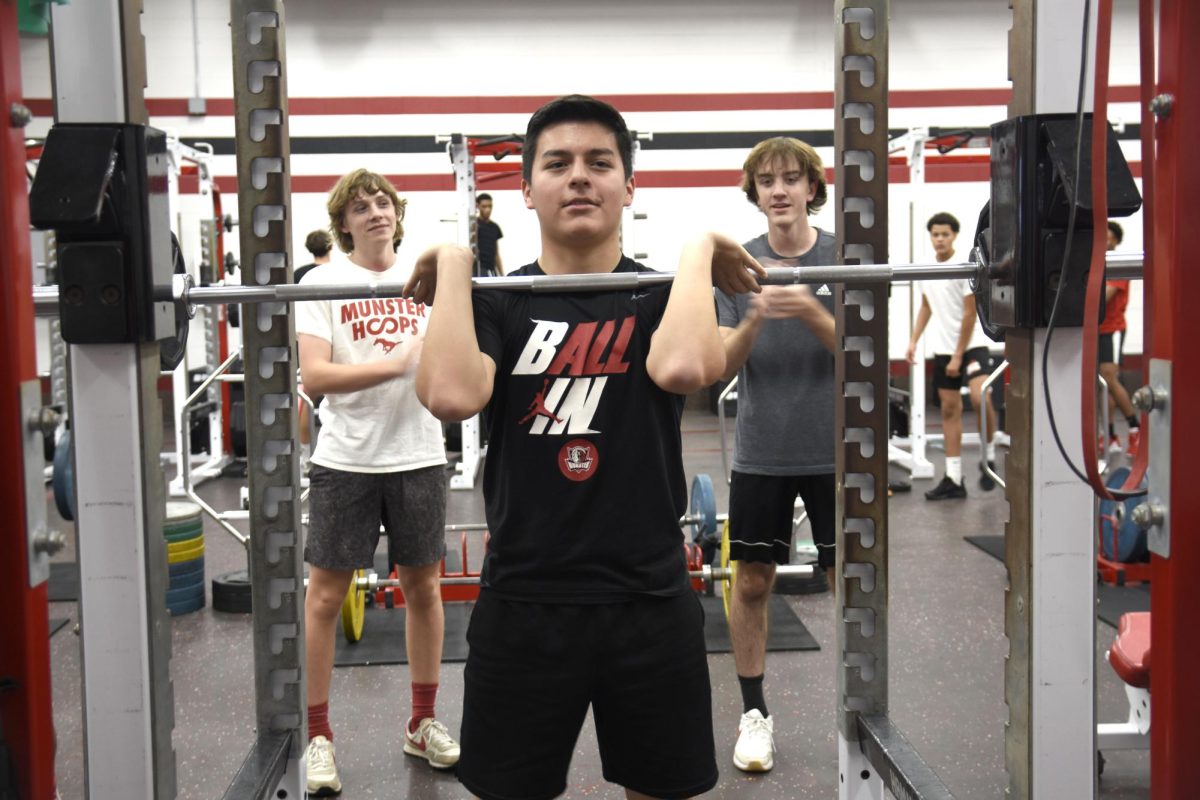 TREAT+GYM+DAY+LIKE+GAME+DAY+Cheering+on+sophomore+Aidan+Prado%2C+sophomores+Jake+Greiner+and+Carter+Moore+watch+as+he+lifts.+In+the+weight+room+after+school%2C+the+boys%E2%80%99+basketball+team+works+on+physical+fitness+in+preparation+for+the+start+of+their+season.+%E2%80%9CTeamwork+is+important+because+it%E2%80%99s+a+good+way+to+motivate+each+other+to+get+stronger+and+work+harder%2C%E2%80%9D+Greiner+said.+
