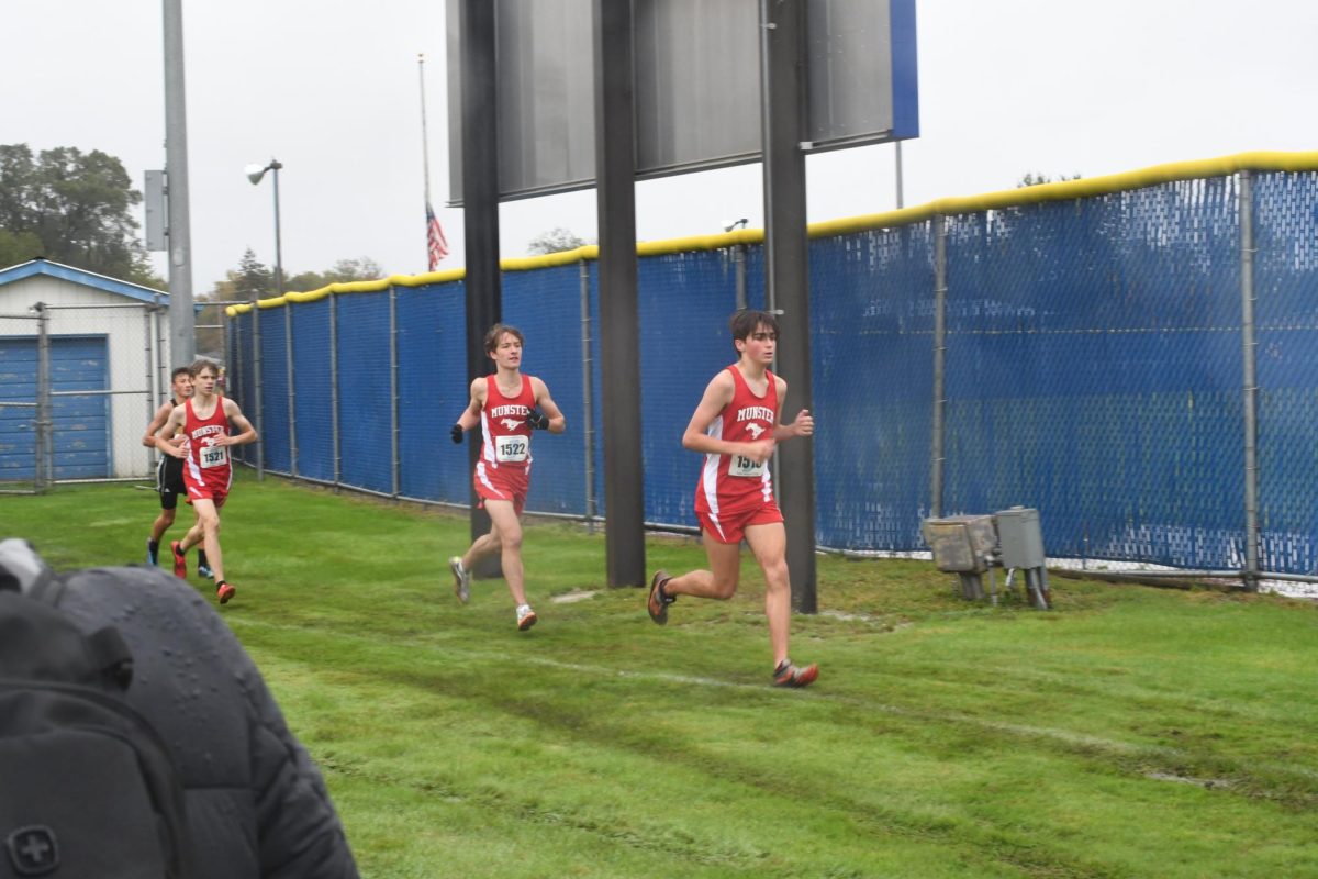 MID SPRINT From left to right, Sebastian Kozy, senior, and Lukas Stewart, junior, pace themselves on their second mile at Sectionals.  “The weather was rainy and cold that day, so it pushed me to go faster to the finish,” Kozy said.