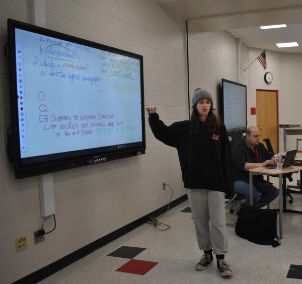 VOICING OUT Communicating her ideas on the board, Addy Ellis, junior, tells her team on what they should focus on their meet. Munster’s debate team went onto Avon and Crown Point with a trail of wins from their past meets. They did not place in any of their meets on Nov. 11. 