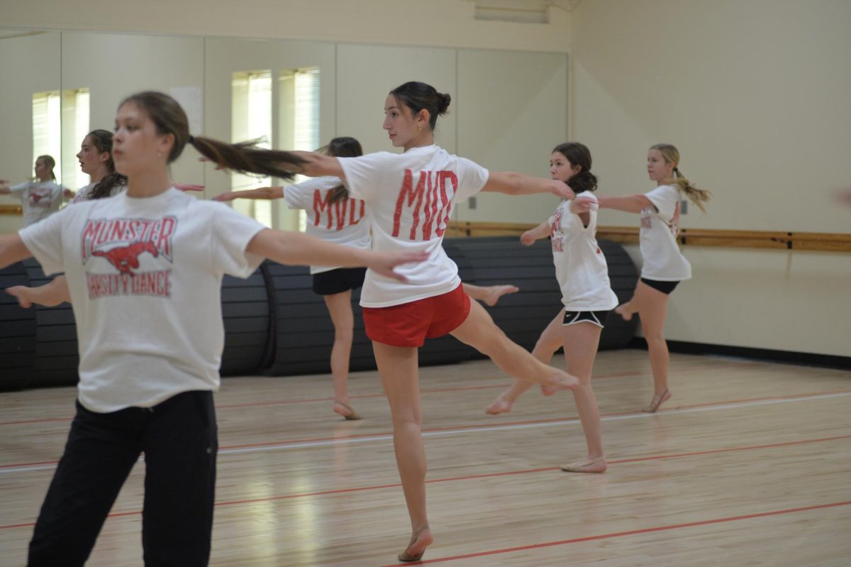 TWIRLING AROUND Perfecting turns in the jazz routine while surrounded by her teammates, Sam Bleza, junior, focuses on herself in the mirror to maintain her balance. The routine will be performed at the showcase along with the pom and game day dances. “This routine brings in different dynamics and movement that challenges our team,” Bleza said. 