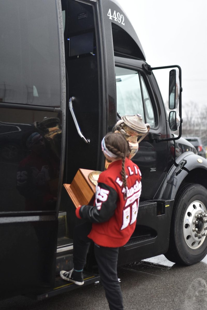 Junior Addy Ellis loads last year’s state trophy onto the bus. “Once we heard that our school won by two points, we all screamed in excitement.”
Addy said.  
