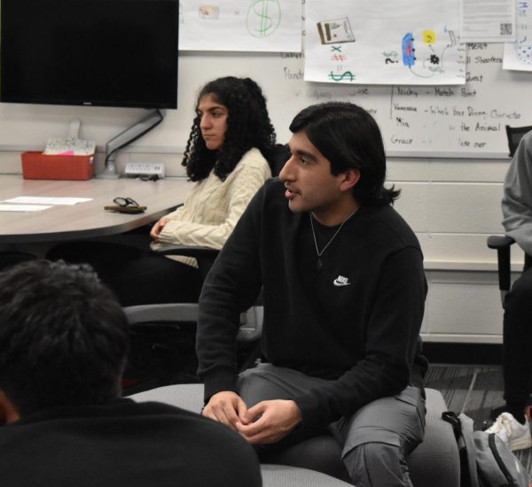 SQUARE ONE Seniors Anthony Ornelas and Dorsa Farahani sit listening at the last DECA meeting. “Being down in Indy for the competition was exciting,” Anthony said. 