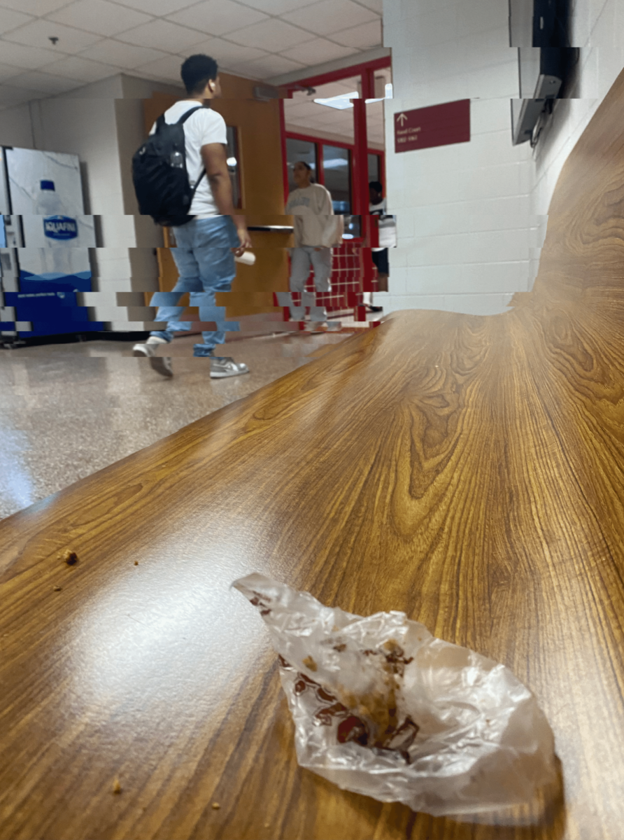 At the end of the school day, on the bench in the hallway before the cafeteria, an empty cookie wrapper can be seen disreguarded on the bench.
