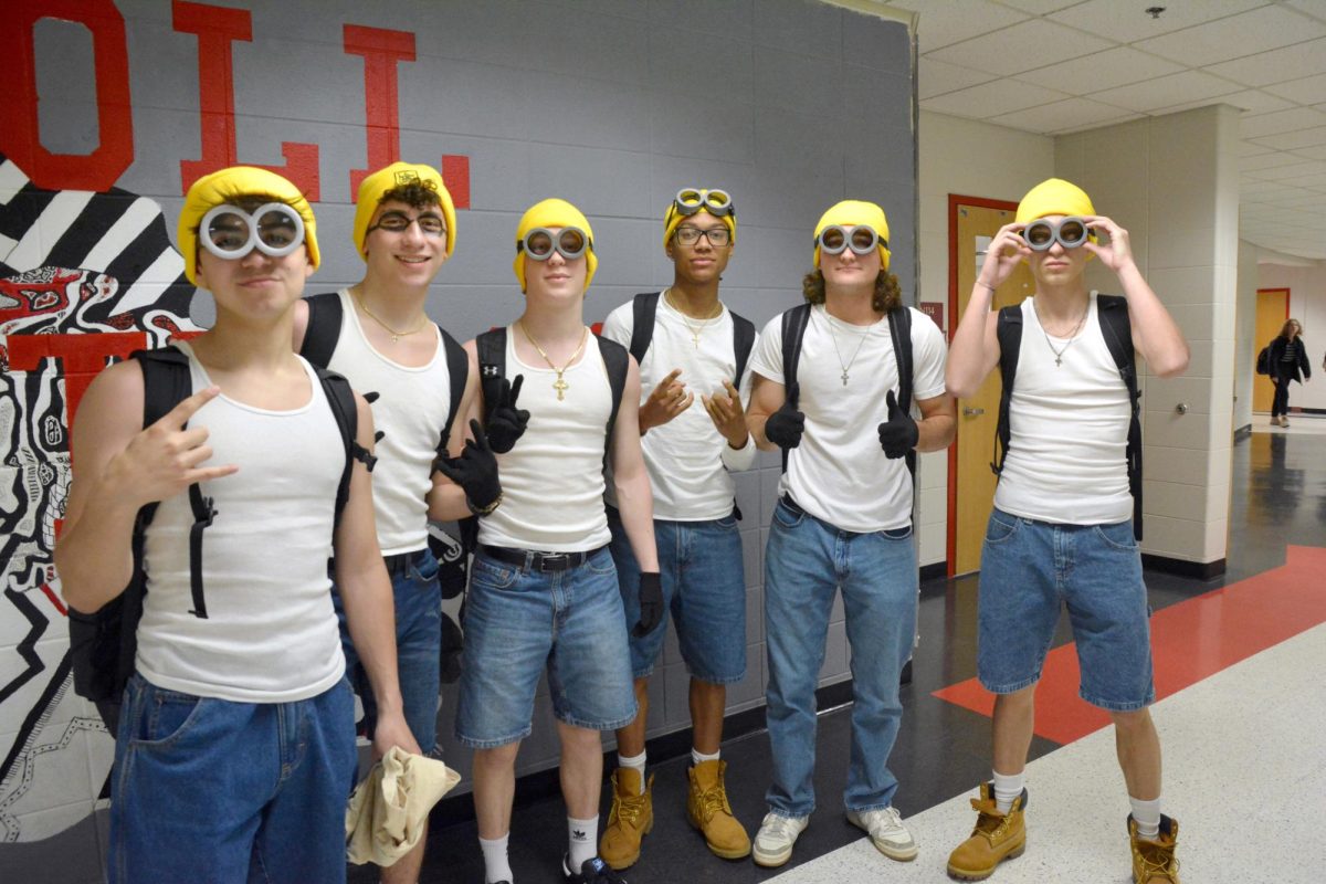 MINION MAHEIM Posing in front of the Mustang mural, seniors Lucas Collier Isaiah Swider, Brandon Petrovski, Myles Shipps, Sam Marich, and Vasili Papageorge dress up as a clan of Minions. (photo by john kullerstrand)