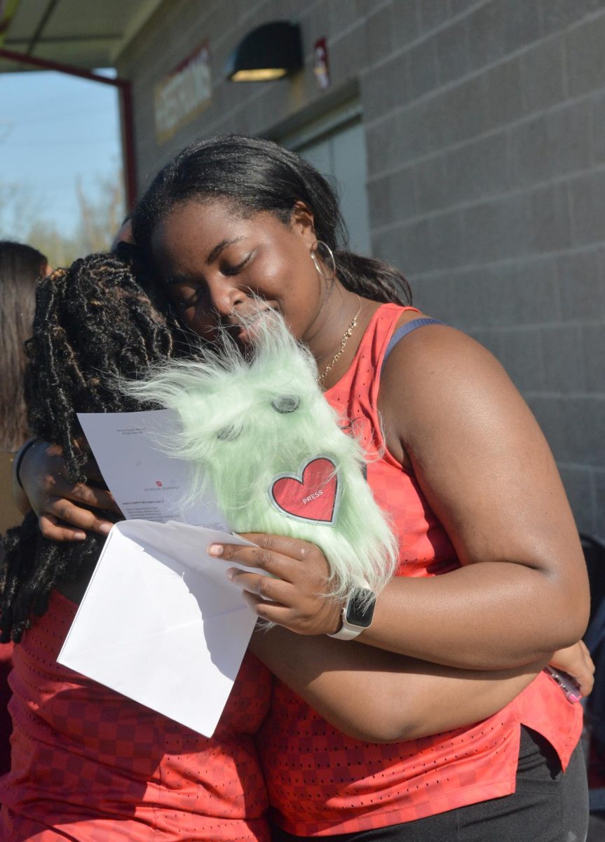 THE END OF AN ERA Holding a handwritten card, Nneka Oniah, senior, hugs Chyaire Love, freshman, at track senior night April 30. “I loved senior night,” Nneka said. “It was a great night to recognize all of the seniors, their accomplishments and see where everyone is headed.” 