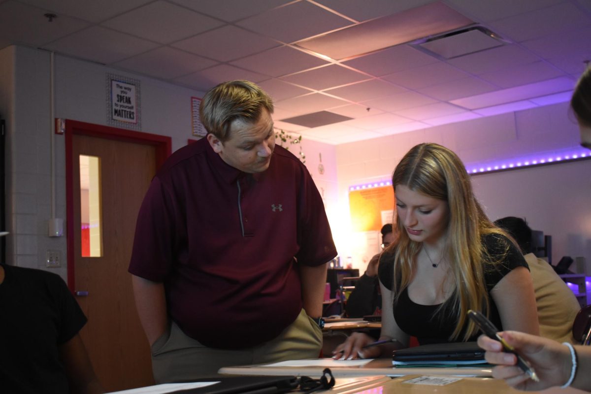 EXTRA EYES Standing beside a student’s desk, Mr. Cameron Adams, math teacher, assists freshman Grace Cundiff with an in-class assignment. 
