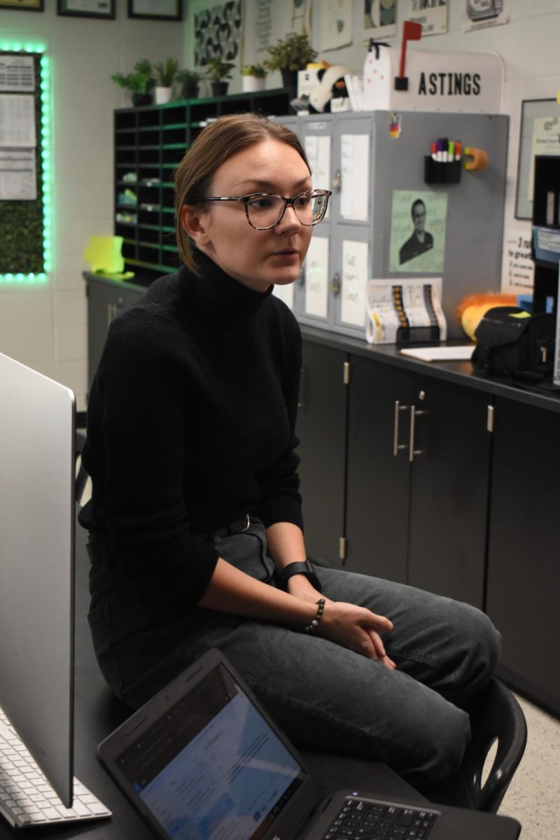 PULL UP A CHAIR Sitting on the desk, Ms. Alexandra Sulewski, discusses interview techniques with a student. 