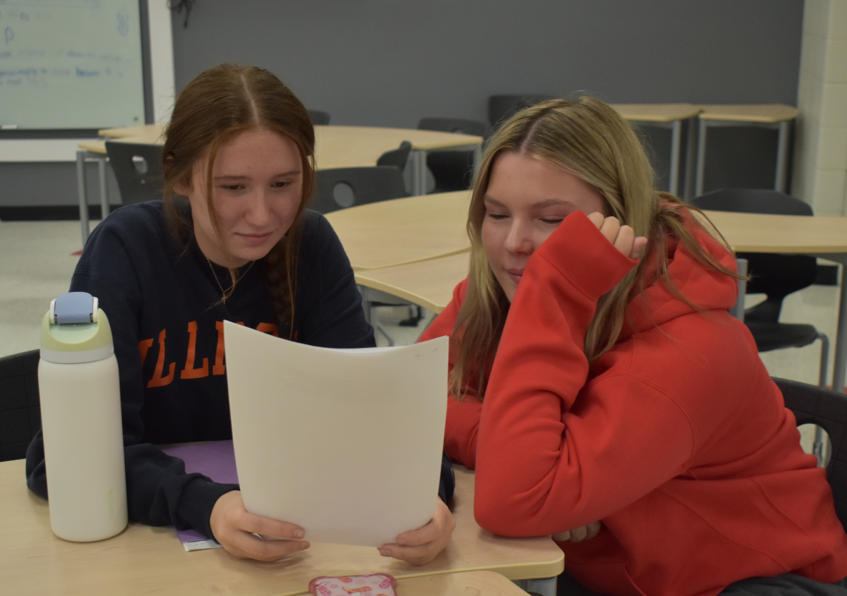 FOCUSED AND DETERMINED Studying their pieces, sophomores Ellie Gelarden and Vivian Petrozza repeat their lines out loud to their peers to memorize their pieces. The speech and debate team is having their first official tournament, Oct. 26 at Homewood Flossmoor.