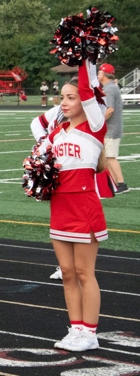 ONE POM AT A TIME On the sidelines, junior Skyler Serna stands in place along with the other cheerleaders. 