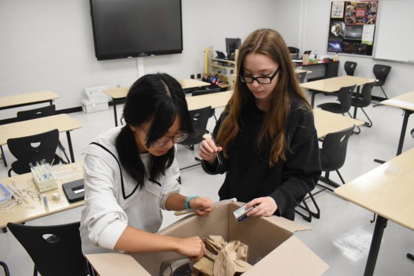 DUSTED OFF As sophomores Kate Huang and Rachel Siergey assemble supplies for their forensics kit, they unpacked old equipment including forceps and flasks. The Science Olympiad members are preparing for the upcoming tournament at Palatine this Saturday. “Science Olympiad constantly challenges us to think creatively, and I love seeing how our team improves with each competition," Kate Huang said.