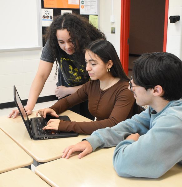 CRACKING THE CODE Looking at a computer, junior Tatyana Glowa and freshmen Julissa Gil and John Bellahcen go through practice images in business teacher Ryan Popa’s room. The three students are apart of one of the three Cyberpatriot teams, Echo. “I started knowing practically nothing and quickly learned how everything works,” Bellahcen said. “I really love competition days where you and your team get 95% percent of the image complete and then have to lock in and as a team work through problems together.”