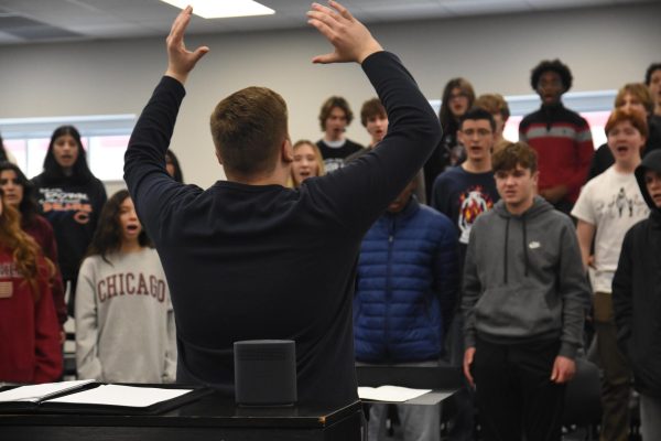 Standing in front of the class, choir director Luke McGinnis conducts his 4th hour class in preparation for Chorale’s future events. “After working on the songs for a long time, it’s great to be able to show everyone how hard we worked for that moment,” senior Meilee Alvarez said.