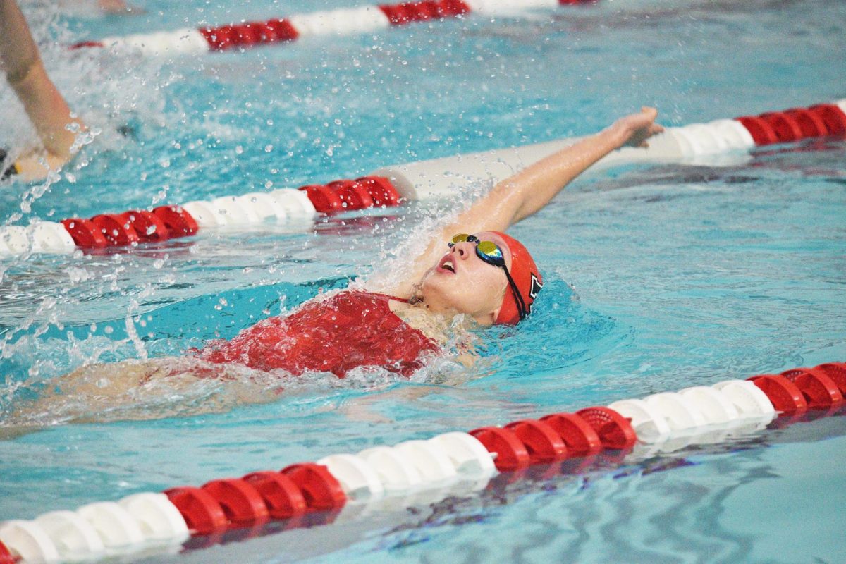 BREATHE IN, BREATHE OUT In her lane performing backstroke, freshman Emilia Buschmann competes against Penn High School for the duel meet. The Munster seahorses went against the Penn’s Kinsgmen on Jan. 11. “I’m mostly just focused on winning, but also underwater because they are the foundation of backstroke overall,” Buschmann said.