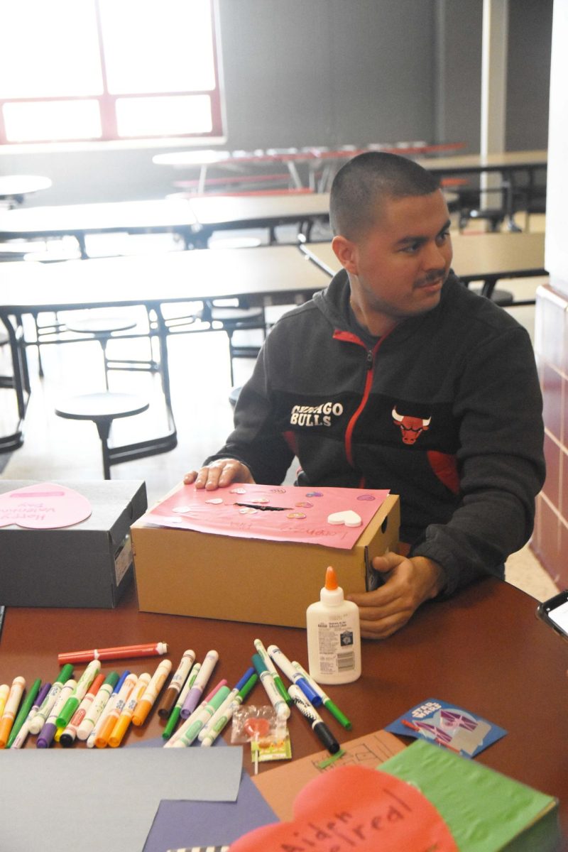 JUST LIKE OLD TIMES Looking over at his peers, senior Lorenzo Piña holds his box  with decorations consisting of construction paper and stickers. Members of Best Buddies made boxes to put their Valentine’s in on their Valentine’s Day party on Feb 9. “Best Buddies is very important club because it’s fun for the special needs kids and other kids,” Piña said.