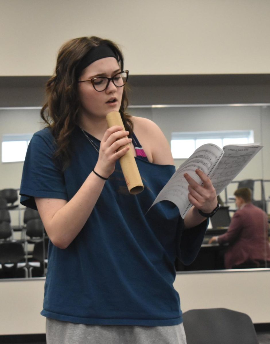 MIC'D UP Rehearsing for the upcoming show, sophomore Emma Potchen uses a fake microphone to practice her singing.  This is her second year of theater. ‘‘We have been doing a lot of stuff in the choir room,” Potchen said. “Which has made it really hard to practice but we have just had to make do with what we have to get this upcoming show ready.” 