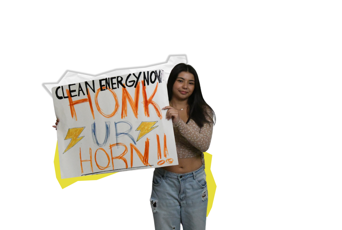 LIVE CLEAN Holding a poster, freshman Nina Hestjean poses with the poster she created and used for the Wicker Park clean energy protest. “Although there were occasional eye rolls or boos, the majority of the traffic was supportive and interactive. I felt like I was making a change and my voice was truly being heard,” Hestjean said.