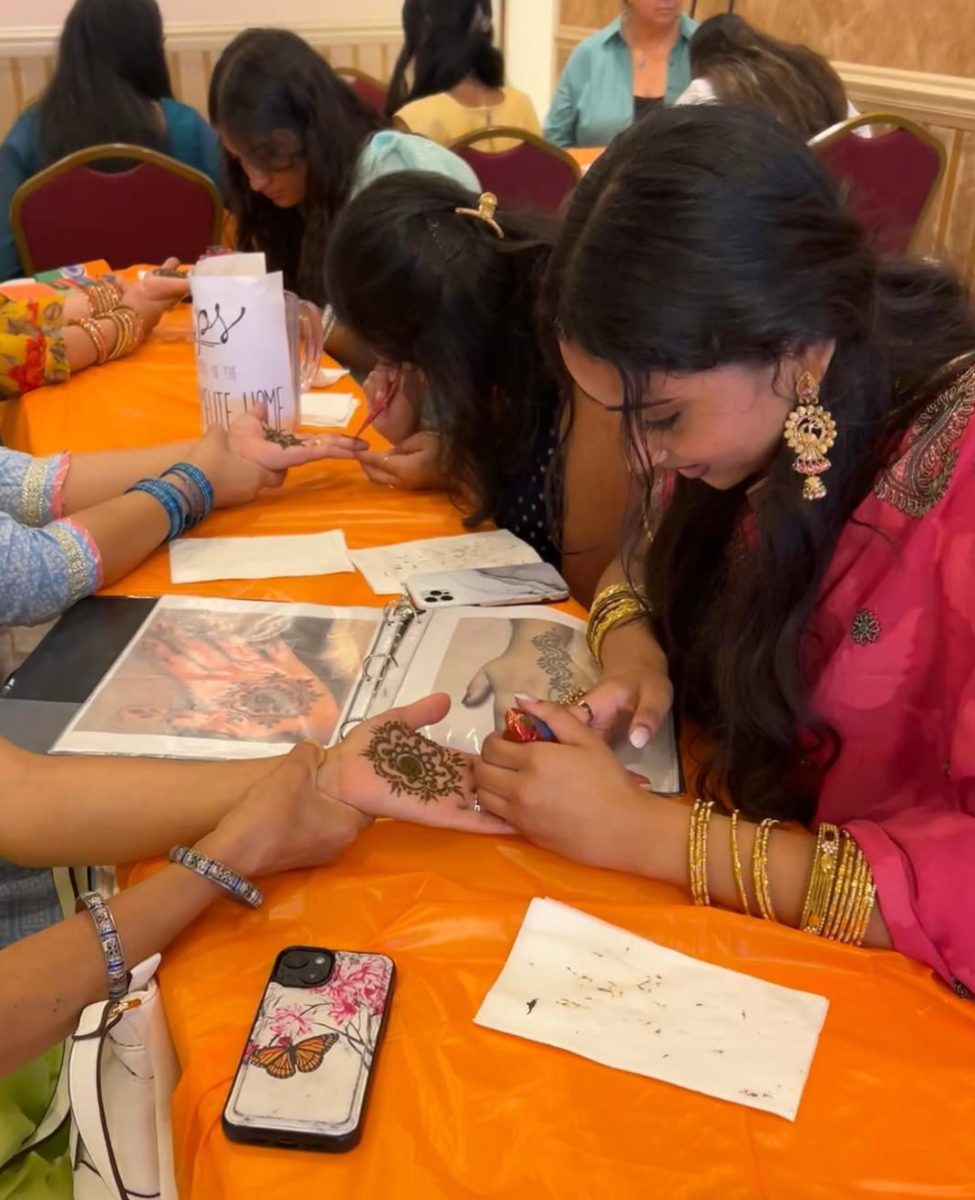 HENNA SPEAKS At the India fest in August, senior Suvali Giridaran does henna at a booth with a customer. The money was raised for the Carmeite home in India. “My most recent clients were at a baby shower, so I did henna there and I earned money and donated that. (Photos provided by Suvali Giridaran)