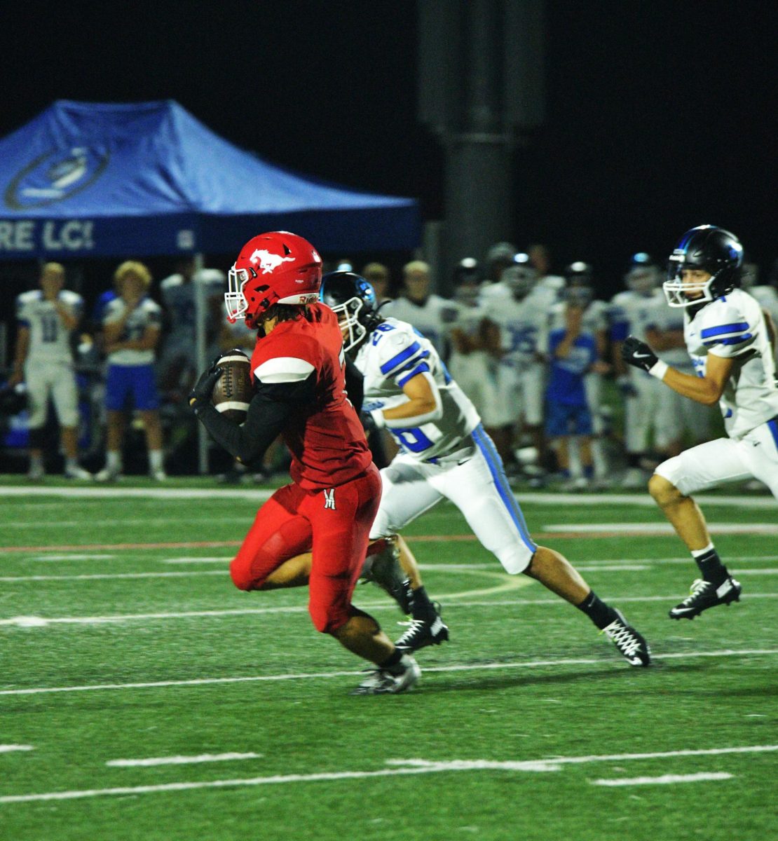 RUN IT DOWN Holding the ball, senior Evan Dennis runs up the field to obtain more yards. Dennis was able to gain thirty-seven yards in the first half of the game. The Mustangs faced Lake Central on Aug. 22.