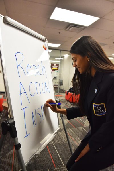 R.A.I. Writing on the whiteboard, junior Raanya Rai works on writing her slogan for her presidential campiagn for Indiana  State DECA. Rai has been campaining since the end of February. 