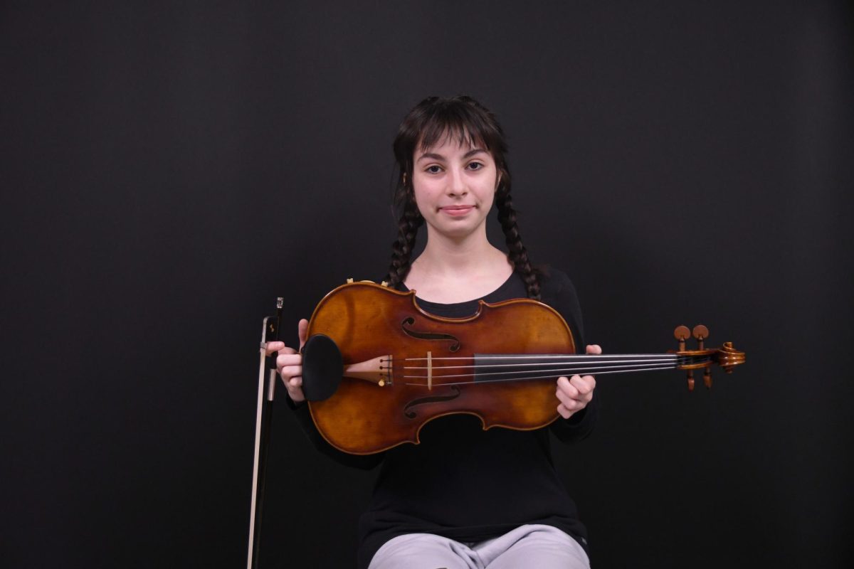PARTNER IN CRIME Holding her viola, senior Olivia Doolin smiles for the camera. Doolin is a part of many national orchestras that compete around the country. “My chamber is called Phoenix, and we are competitive, we’re doing a bunch of competitions right now,” Doolin said.