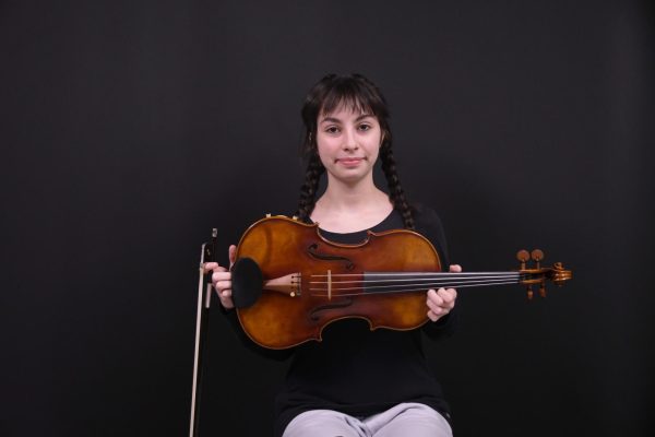 PARTNER IN CRIME Holding her viola, senior Olivia Doolin smiles for the camera. Doolin is a part of many national orchestras that compete around the country. “My chamber is called Phoenix, and we are competitive, we’re doing a bunch of competitions right now,” Doolin said. 